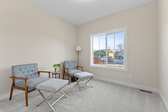 sitting room featuring light carpet