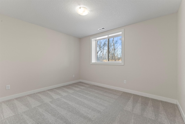 carpeted spare room with a textured ceiling