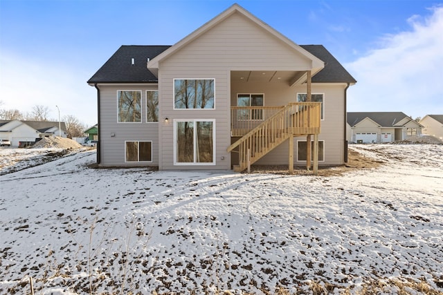 snow covered house with a wooden deck