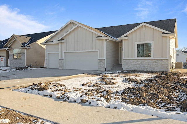 view of front facade featuring a garage and central air condition unit