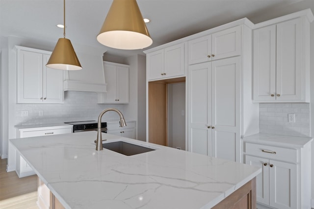 kitchen with white cabinetry, tasteful backsplash, pendant lighting, and light stone countertops