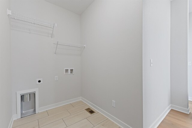 clothes washing area featuring light wood-type flooring, hookup for an electric dryer, and washer hookup