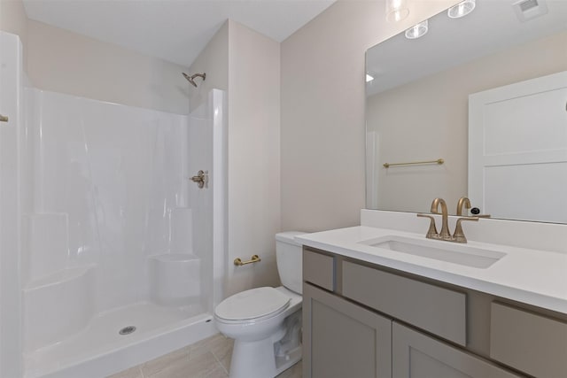 bathroom featuring vanity, tile patterned flooring, a shower, and toilet