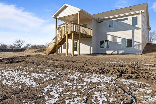 snow covered back of property featuring a deck