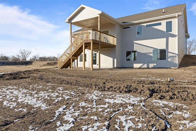 snow covered rear of property with a wooden deck