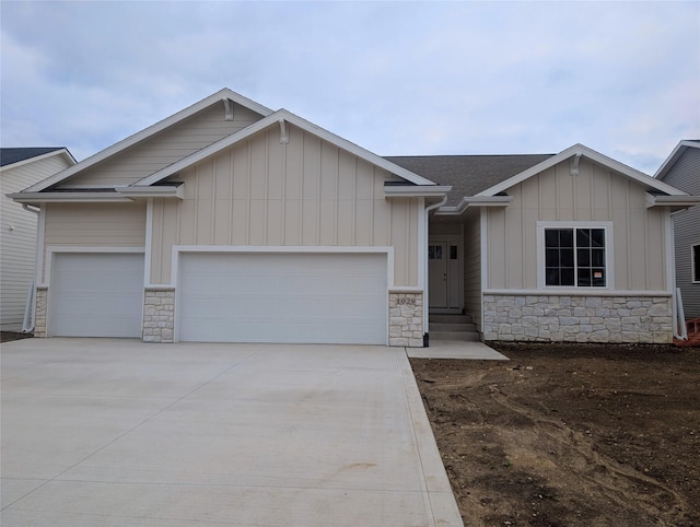1028 2nd St NE, Altoona, IA 50009 - craftsman-style house with stone siding, an attached garage, and board and batten siding