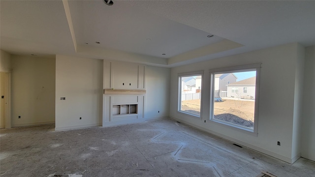 unfurnished living room featuring a raised ceiling