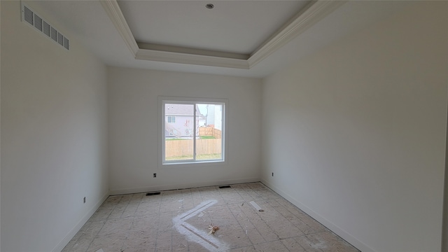 spare room featuring a tray ceiling and ornamental molding