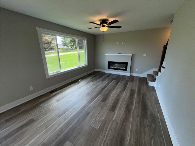 unfurnished living room featuring dark hardwood / wood-style floors and ceiling fan