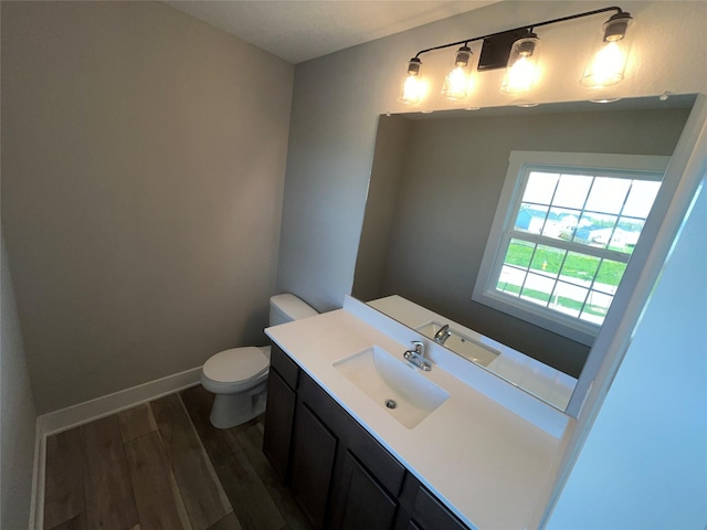 bathroom featuring toilet, vanity, and hardwood / wood-style flooring