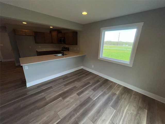 kitchen featuring kitchen peninsula, sink, and light wood-type flooring