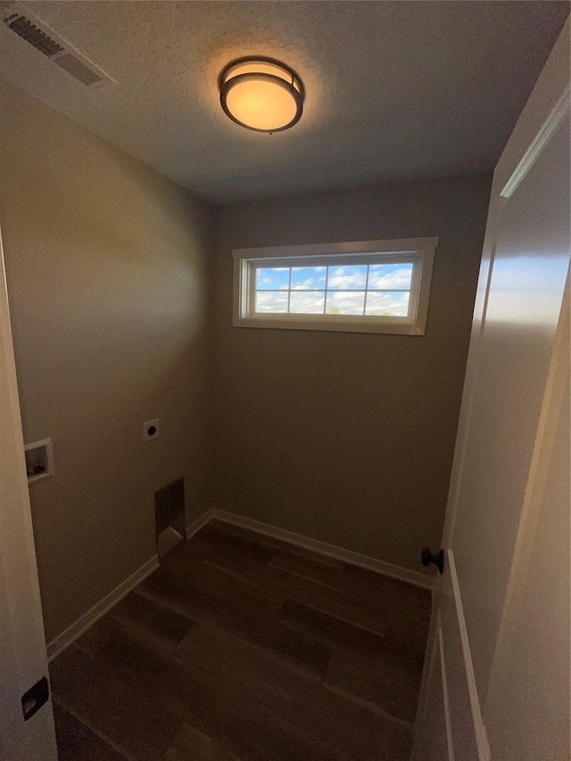 washroom featuring hookup for an electric dryer, a textured ceiling, and dark wood-type flooring