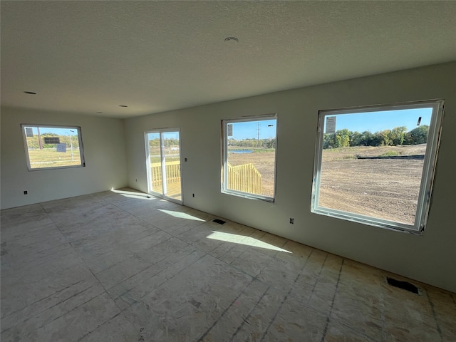 unfurnished room with a textured ceiling