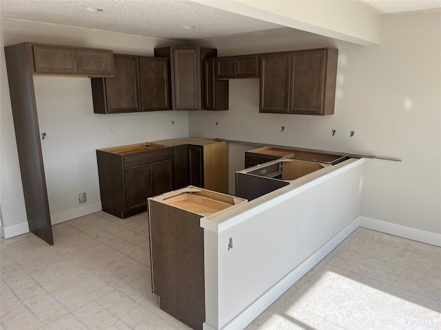 kitchen featuring dark brown cabinets and a textured ceiling