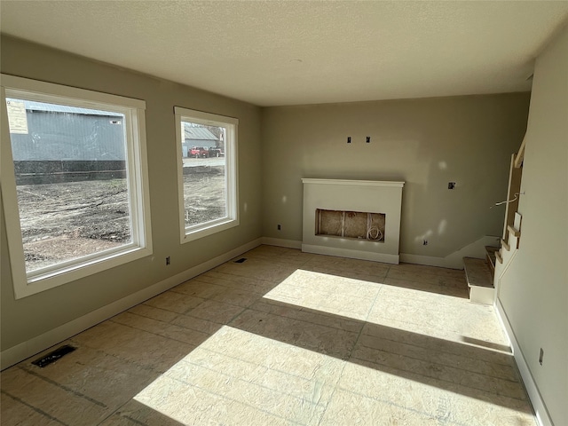 unfurnished living room with a fireplace and a textured ceiling