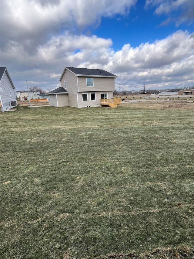 exterior space featuring a rural view, a lawn, and a wooden deck