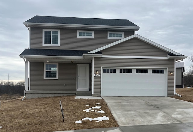 view of front of house featuring a shingled roof, concrete driveway, and an attached garage