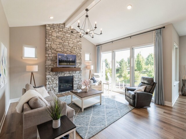 living room featuring a fireplace, wood-type flooring, vaulted ceiling with beams, and a notable chandelier