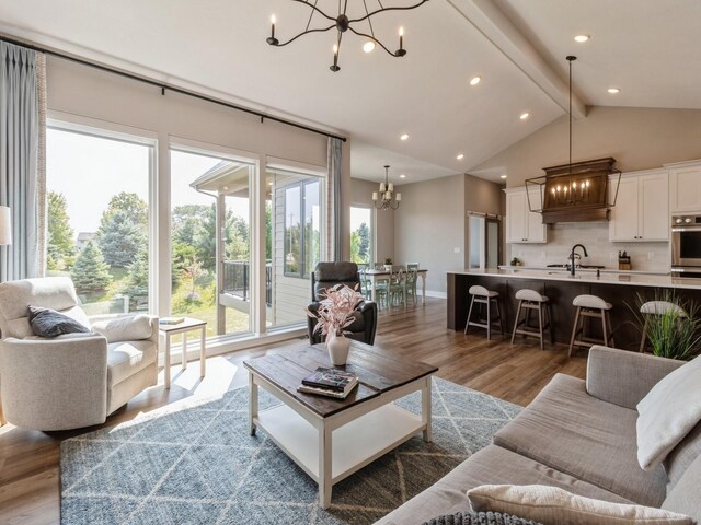 living room with wood-type flooring, sink, and a notable chandelier