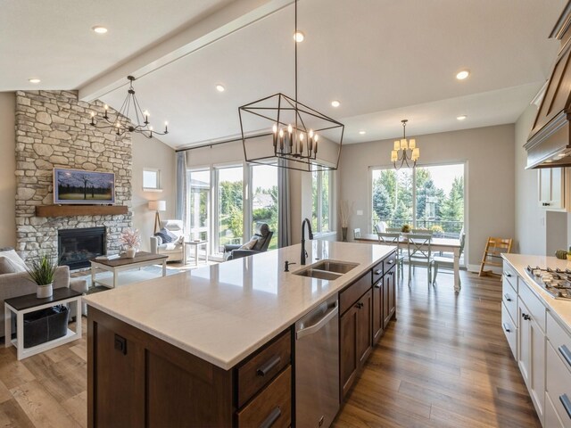 kitchen with sink, white cabinetry, decorative light fixtures, and light hardwood / wood-style floors