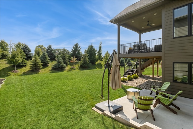 view of yard featuring ceiling fan, a deck, and a patio area