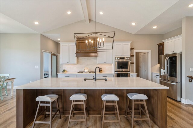 kitchen with stainless steel appliances, light hardwood / wood-style floors, and a large island