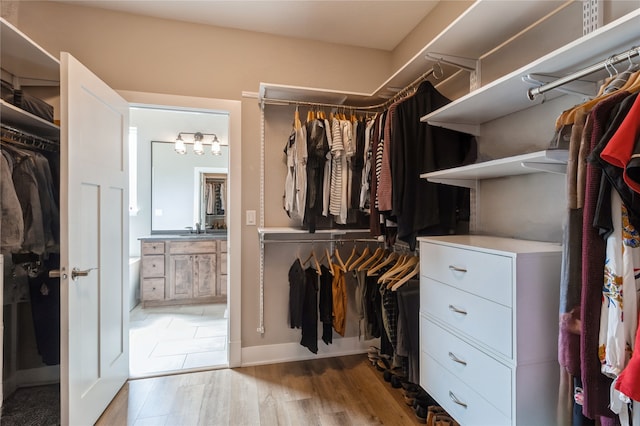 walk in closet featuring light hardwood / wood-style floors and sink