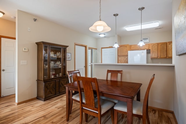 dining area with baseboards, visible vents, and light wood-style floors