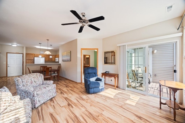 living room featuring a ceiling fan, visible vents, and light wood-style floors