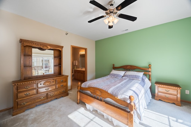 carpeted bedroom with a ceiling fan, visible vents, and ensuite bath