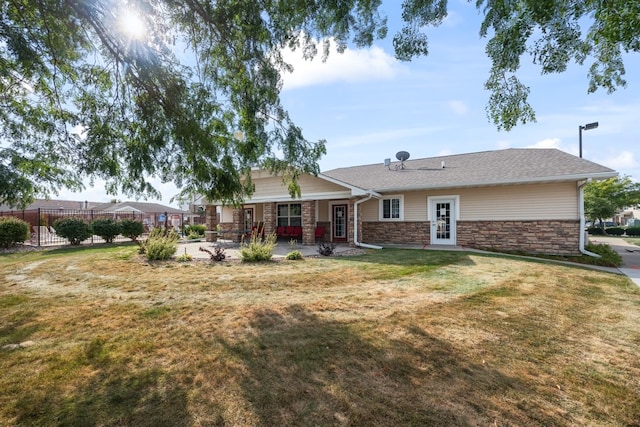 back of house with french doors, a patio, a lawn, fence, and stone siding