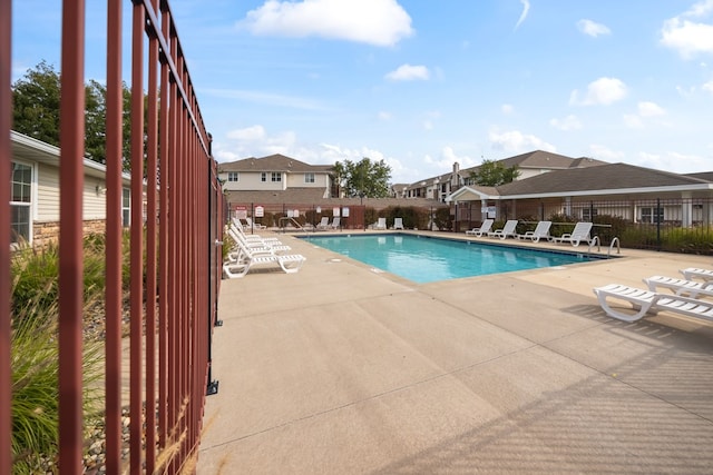 pool with a residential view, fence, and a patio