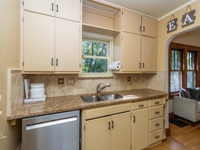 kitchen with light stone countertops, sink, dishwasher, light wood-type flooring, and decorative backsplash