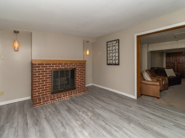 unfurnished living room featuring a brick fireplace and hardwood / wood-style floors