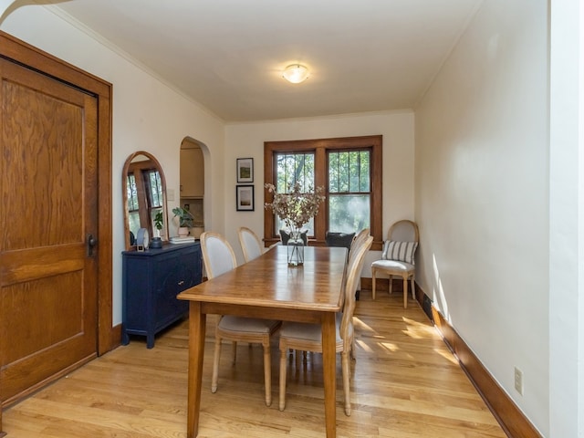 dining room featuring ornamental molding and light wood-type flooring