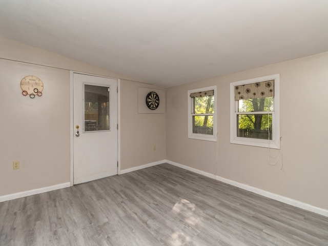 empty room featuring vaulted ceiling and wood-type flooring