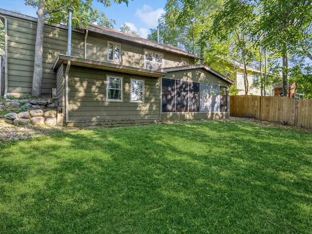 back of property featuring a lawn and a sunroom