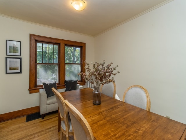 dining room with light hardwood / wood-style floors and crown molding