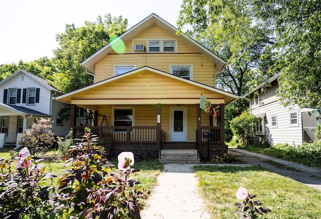 view of front of house with a front lawn, central AC unit, and a porch