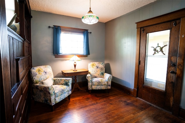 living area featuring a textured ceiling and dark hardwood / wood-style flooring