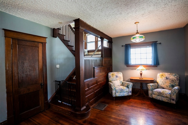 living area with dark hardwood / wood-style floors and a textured ceiling