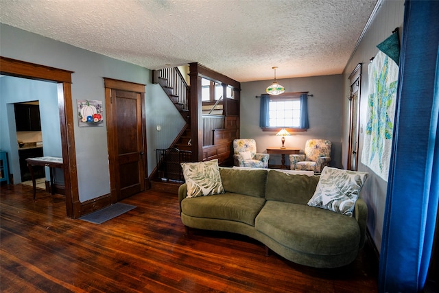 living room with dark hardwood / wood-style floors and a textured ceiling