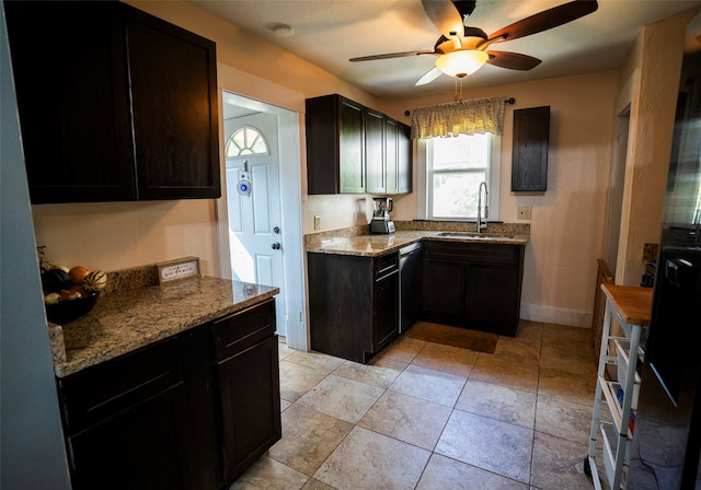 kitchen with light stone counters, stainless steel dishwasher, ceiling fan, and sink