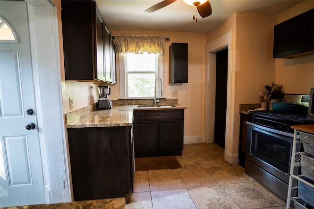 kitchen with ceiling fan, sink, dark brown cabinetry, and stainless steel gas range oven