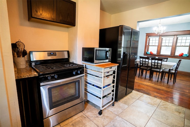 kitchen featuring a notable chandelier, dark brown cabinets, light hardwood / wood-style flooring, decorative light fixtures, and appliances with stainless steel finishes