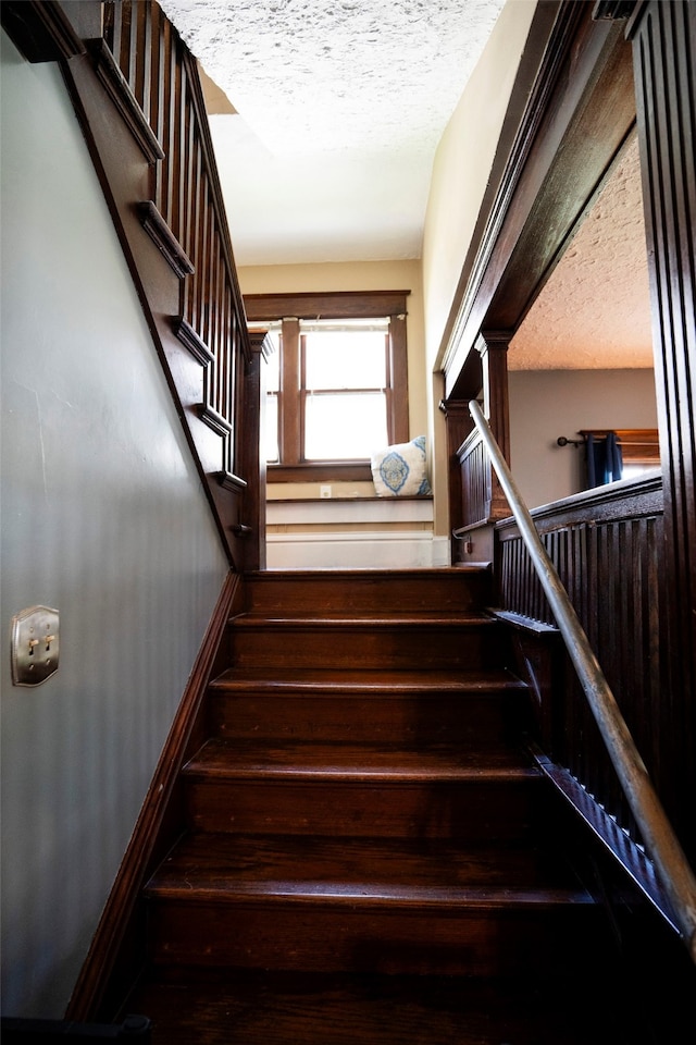 stairs with a textured ceiling