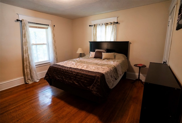 bedroom with dark hardwood / wood-style floors