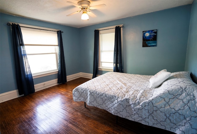 bedroom featuring ceiling fan, dark hardwood / wood-style flooring, and a textured ceiling