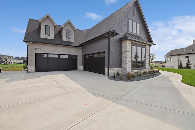 18252 Valleyview Cir, Clive, IA 50325 - view of front of home featuring stone siding, concrete driveway, roof with shingles, and an attached garage