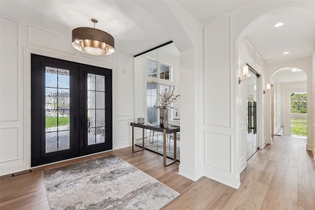 foyer featuring a healthy amount of sunlight, light hardwood / wood-style flooring, and french doors